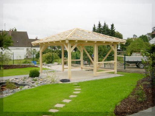 Offener Holzpavillon mit Ziegeldach in einem grünen Garten